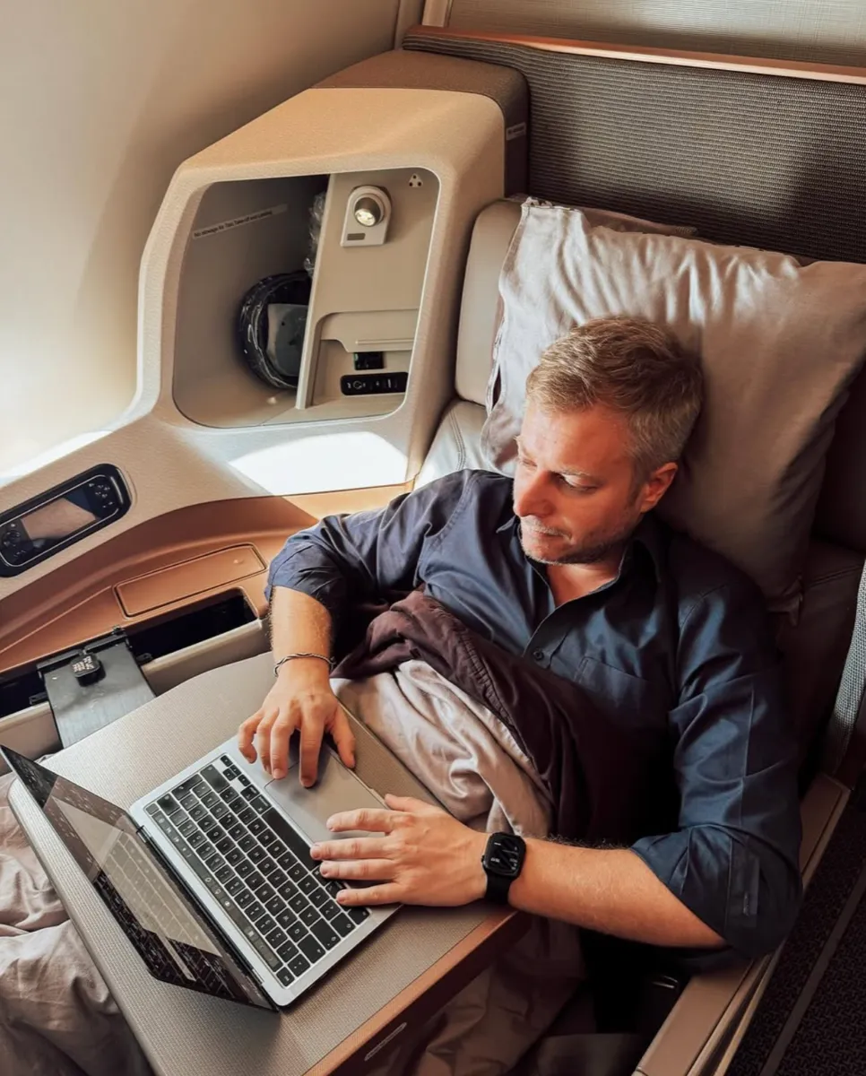 Fabian Hilpert arbeitet in der First Class am Laptop